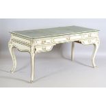 An early 20th century French Louis XV style cream painted and gilt bureau plat writing desk,