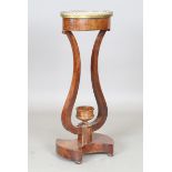 A French Empire mahogany guéridon stand, the oval top inset with white marble above a pair of lyre