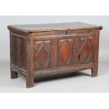 An 18th century oak panelled coffer, the hinged lid above a carved lozenge front, height 78cm, width