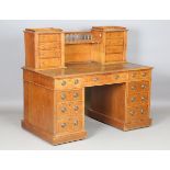 An Edwardian oak twin pedestal desk, the gallery back fitted with eight drawers above an arrangement