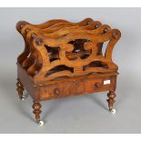 A late Victorian walnut three-division Canterbury, raised on china castors, height 50cm, width 51cm,