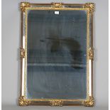 A modern Italianate gilt composition sectional wall mirror with distressed outer border sections,