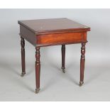A Victorian mahogany fold-over games table, the revolving top above reeded legs and castors,