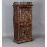 A small late 19th/early 20th century Flemish oak side cabinet, one door carved with two musicians,