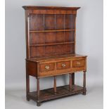 A late George III provincial oak dresser, the plate rack above three frieze drawers and a pot shelf,