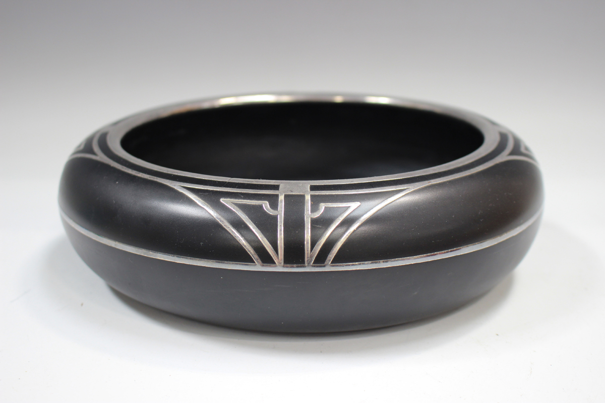 A black glass and silver inlaid circular bowl, in the Art Deco taste, indistinct number to base,