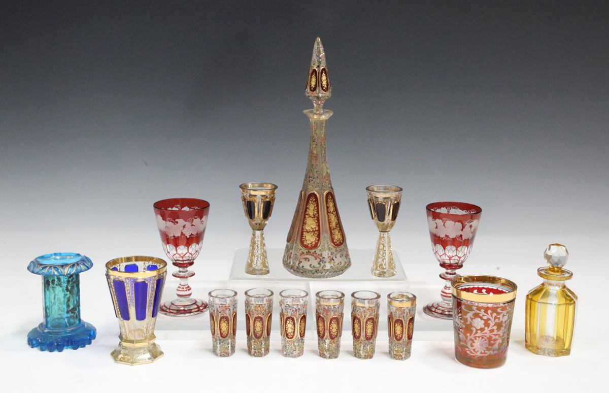 A Bohemian ruby flashed and enamelled glass liqueur set, early 20th century, each piece with a