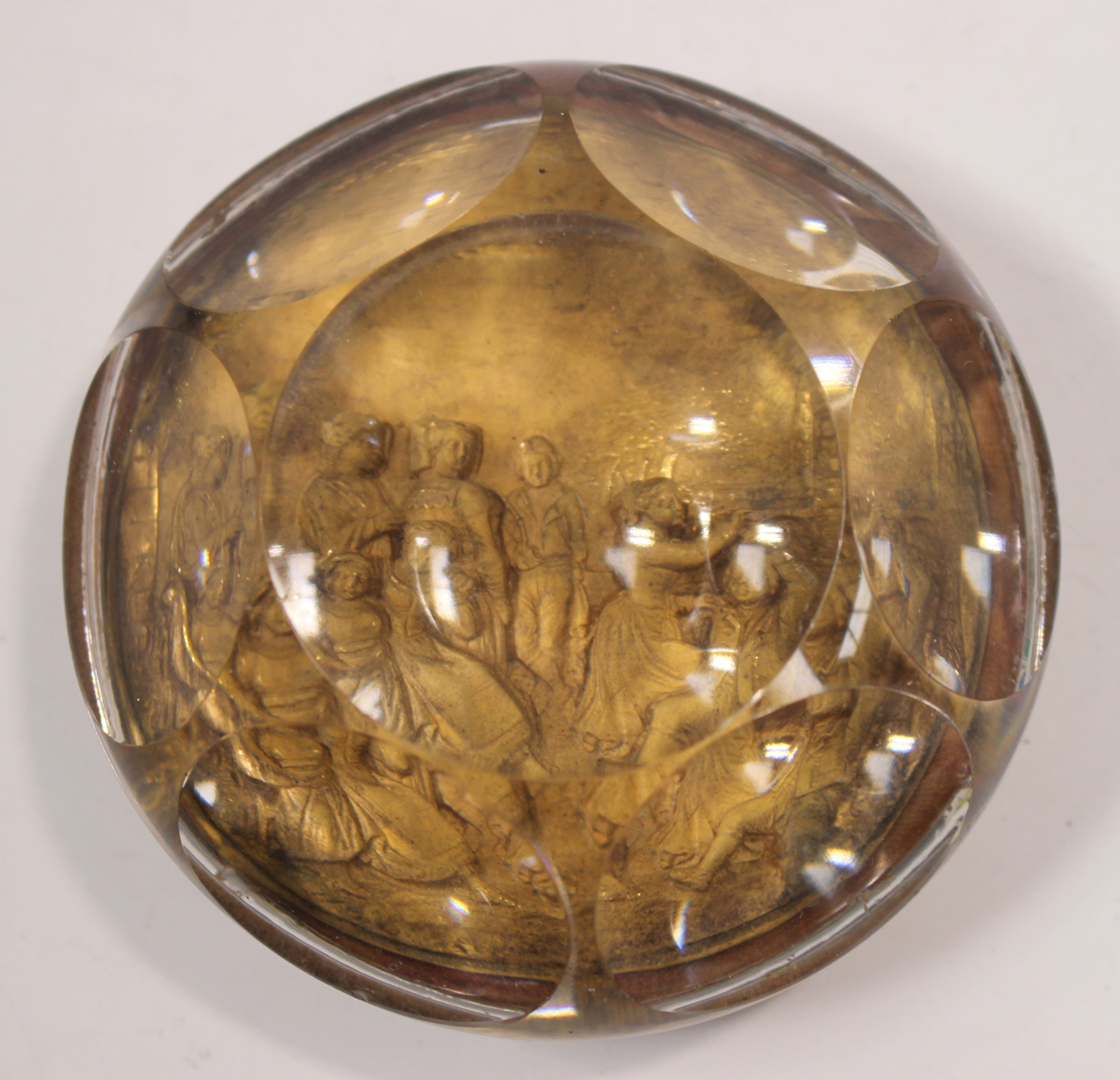 A Pinchbeck faceted glass paperweight, 19th century, depicting a figural pastoral scene, diameter