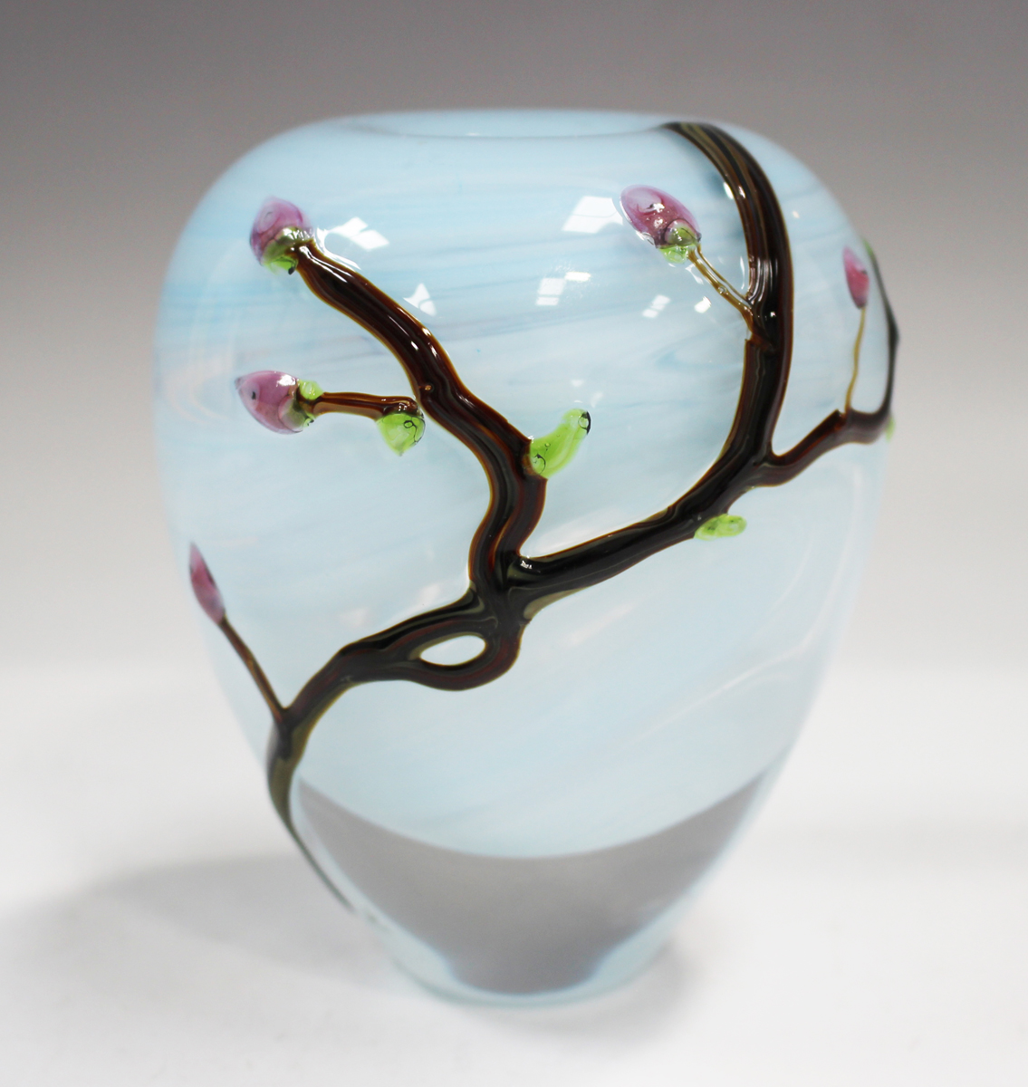 A Siddy Langley studio glass vase, circa 2022, decorated with budding tree branches against a pale