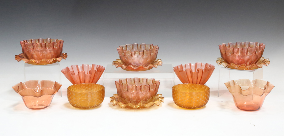 A set of four gold threaded over cranberry glass finger bowls and stands, probably Stevens &