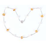 A white gold, citrine and cultured pearl necklace, spaced with faceted dish shaped citrines