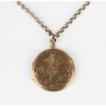 A 9ct gold circular pendant locket with scroll engraved decoration, Birmingham 1969, length 3.7cm,