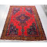 A Hamadan rug, North-west Persia, late 20th century, the red field with a shaped medallion, within a