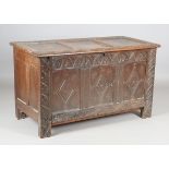 An early 18th century oak coffer, the triple-panel hinged lid above a stop fluted frieze and
