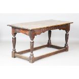 A 17th century and later oak refectory table, the carved frieze above turned and block legs,