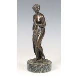 A late 19th century Continental brown patinated cast bronze figure of the Bathing Venus, raised on a