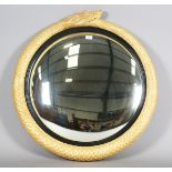 A modern Empire style gilded composite circular wall mirror, the frame finely modelled as a