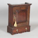 An 18th century provincial oak spice cupboard, the hinged door inset with a mahogany panel,
