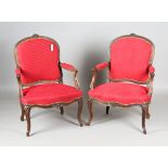 A pair of 20th century Louis XV style stained beech showframe fauteuil armchairs, upholstered in red