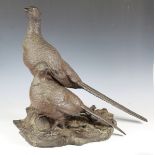 A large late 20th century bronzed resin model of two pheasants, mounted on a naturalistic base,