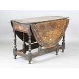 An 18th century oak oval drop-flap dining table, the top later carved with an outer border of script