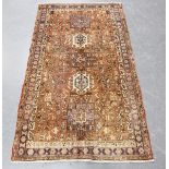 A Heriz rug, North-west Persia, mid/late 20th century, the faded red field with a column of hooked