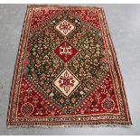 An Afghan rug, late 20th century, the red field with three stepped medallions, supported by