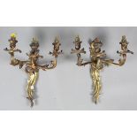 A pair of early 20th century rococo style gilt brass three-branch wall lights, backplate height