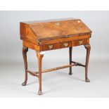 An 18th century and later walnut bureau, the feather banded fall flap enclosing drawers and a well