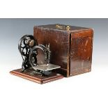 A 19th century Willcox & Gibbs sewing machine, mounted on a walnut plinth, width 32cm, cased.Buyer’s