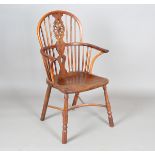 An early Victorian yew and elm stick and wheel back Windsor armchair with shaped panel seat and