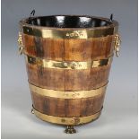 An early 20th century coopered oak and brass mounted fireside bucket with lion mask handles and claw