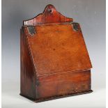 An 18th century provincial oak wall mounted candle box, the sloping lid with leather hinges,