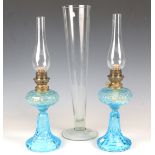A pair of early 20th century moulded blue glass paraffin lamps, height to top of fitting 29cm,