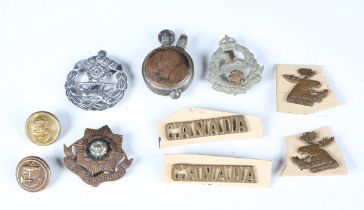 A collection of 20th century cap badges, shoulder titles and buttons, including Canadian, Royal