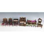 A suite of Walterhausen doll's house furniture, gilt decorated with leaf scrolls and emblems,