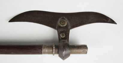 A 19th century Middle Eastern steel headed and white metal mounted battle axe, mounted on a hardwood