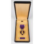 A USA gilt metal and enamelled Purple Heart Medal, detailed 'For Military Merit', with a ribbon bar,