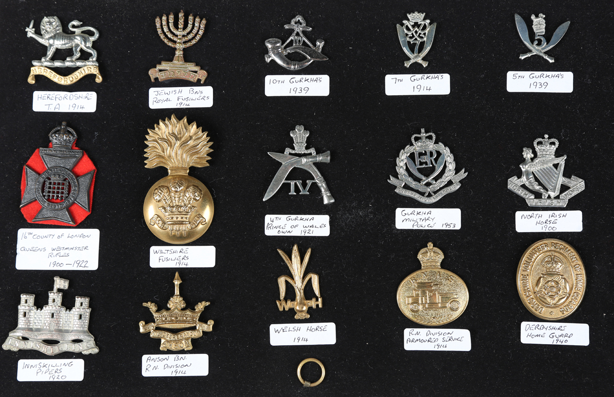 A large collection of 20th century British military and other cap badges, including a silver Buffs