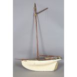 A mid-20th century pond yacht with faux planked deck and painted hull, length 87cm.Buyer’s Premium