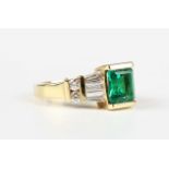A gold, emerald and diamond ring, mounted with a cut cornered rectangular step cut emerald between