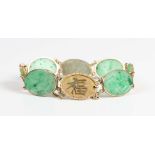 An Asian gold and jade bracelet, mounted with four oval jade panels alternating with four