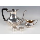 A late Victorian silver half-reeded baluster coffee pot and matching milk jug, each with a gadrooned