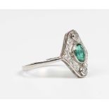 A platinum, emerald and diamond ring, collet set with the oval cut emerald within a pierced shaped