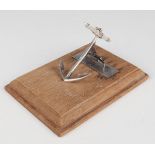 A George VI silver anchor desk clip, mounted on a later rectangular oak base, London 1938 by