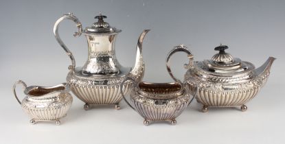 A late Victorian silver four-piece tea set of half-reeded cushion form, embossed with bands of
