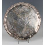 A George III silver circular salver, engraved with a shield shaped cartouche centred by a crest,