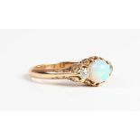 A gold, opal and diamond ring, circa 1900, claw set with a circular cabochon opal between two old