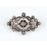 A silver and diamond brooch, probably Indian, in a pierced openwork design, mounted with foil backed