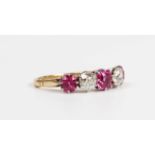 A gold, platinum, ruby and diamond five stone ring, claw set with three cushion cut rubies